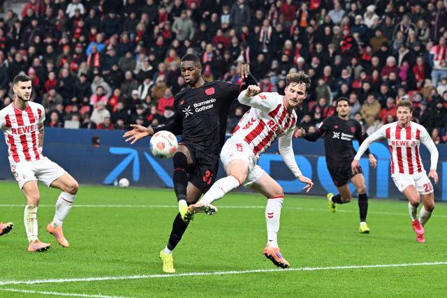 13 December 2025, North Rhine-Westphalia, Leverkusen: Bayer Leverkusen's Christian Kofane (L) and Cologne's Rav van den Berg battle for the ball during the German Bundesliga soccer match between Bayer Leverkusen and 1. FC Cologne at BayArena. Photo: Federico Gambarini/dpa - WICHTIGER HINWEIS: Gemäß den Vorgaben der DFL Deutsche Fußball Liga bzw. des DFB Deutscher Fußball-Bund ist es untersagt, in dem Stadion und/oder vom Spiel angefertigte Fotoaufnahmen in Form von Sequenzbildern und/oder videoähnlichen Fotostrecken zu verwerten bzw. verwerten zu lassen.