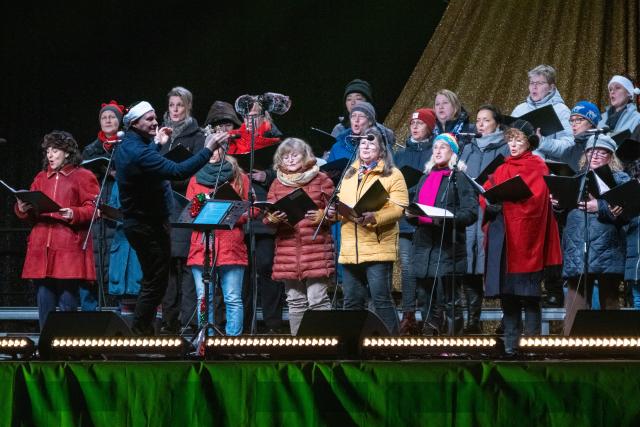 13 December 2025, Mecklenburg-Western Pomerania, Rostock: A choir sings on stage during the Christmas caroling at the Ostseestadion. Photo: Stefan Sauer/dpa