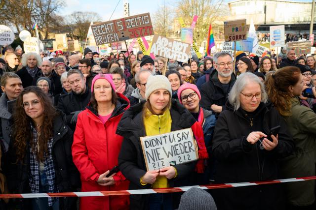 13 December 2025, Hamburg: A participant stands in the front row in front of the stage with a sign reading "Didn't you say Nie Wieder?" during the second "PRUeF" demonstration to demand the Federal Constitutional Court to investigate all parties classified as suspected cases by the Office for the Protection of the Constitution. Photo: Gregor Fischer/dpa