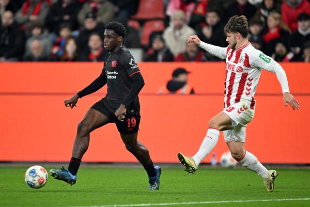 13 December 2025, North Rhine-Westphalia, Leverkusen: Bayer Leverkusen's Ernest Poku (L) and Cologne's Jan Thielmann battle for the ball during the German Bundesliga soccer match between Bayer Leverkusen and 1. FC Cologne at BayArena. Photo: Federico Gambarini/dpa - WICHTIGER HINWEIS: Gemäß den Vorgaben der DFL Deutsche Fußball Liga bzw. des DFB Deutscher Fußball-Bund ist es untersagt, in dem Stadion und/oder vom Spiel angefertigte Fotoaufnahmen in Form von Sequenzbildern und/oder videoähnlichen Fotostrecken zu verwerten bzw. verwerten zu lassen.