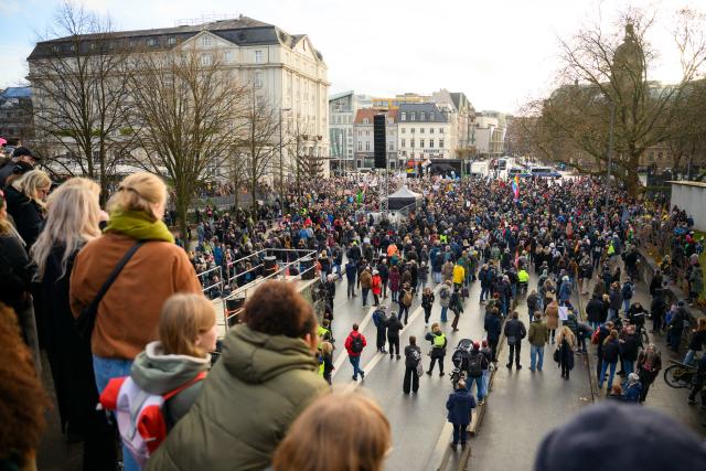 13 December 2025, Hamburg: People stand on a pedestrian bridge over the Dammtordamm during the second "PRUeF" demonstration to demand the Federal Constitutional Court to investigate all parties classified as suspected cases by the Office for the Protection of the Constitution. Photo: Gregor Fischer/dpa