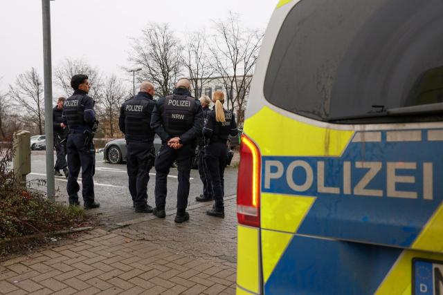 13 December 2025, North Rhine-Westphalia, Luedenscheid: Police officers stand at a parking lot after an accident. A senior citizen had hit a mother and her child. Photo: Tim Oelbermann/dpa