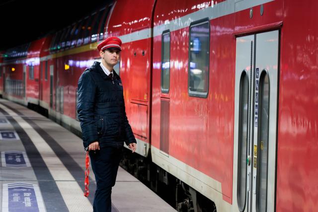 14 December 2025, Berlin: A conductor looks over a platform at the main station in Berlin. The new Deutsche Bahn timetable comes into effect today. Photo: Carsten Koall/dpa