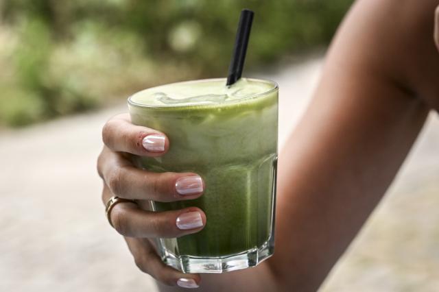 FILED - 23 June 2025, Berlin: A woman holds an iced matcha cup. Government and industry data in Japan show that green tea exports during the first ten months of this year reached their highest level in more than 70 years, driven by a booming overseas matcha powder market and the depreciation of the Japanese yen. Photo: Jens Kalaene/dpa