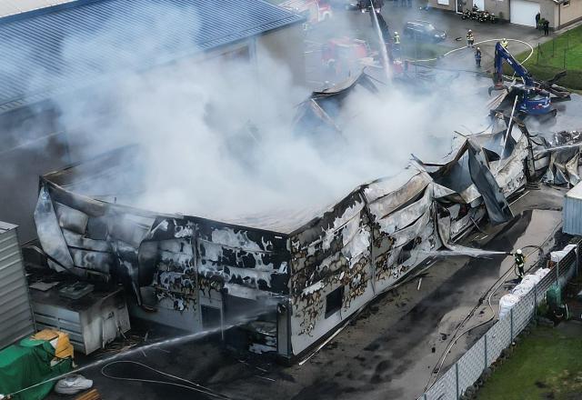 14 December 2025, Lower Saxony, Westoverledingen: Numerous volunteer firefighters battle a major fire since the early hours of the morning. According to the police, 150 firefighters from the surrounding area have been in action since the early hours of the morning. A fire has destroyed a hall belonging to a furniture company in the district of Leer and caused millions in damage. Photo: Lars Penning/dpa