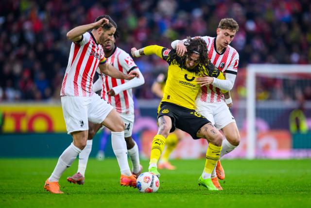14 December 2025, Baden-Wuerttemberg, Freiburg im Breisgau: Borussia Dortmund's Fabio Silva (2nd R) and Freiburg's Christian Guenter (L) and Freiburg's Patrick Osterhage (R) battle for the ball during the German Bundesliga soccer match between SC Freiburg and Borussia Dortmund at Europa-Park Stadium. Photo: Tom Weller/dpa - WICHTIGER HINWEIS: Gemäß den Vorgaben der DFL Deutsche Fußball Liga bzw. des DFB Deutscher Fußball-Bund ist es untersagt, in dem Stadion und/oder vom Spiel angefertigte Fotoaufnahmen in Form von Sequenzbildern und/oder videoähnlichen Fotostrecken zu verwerten bzw. verwerten zu lassen.
