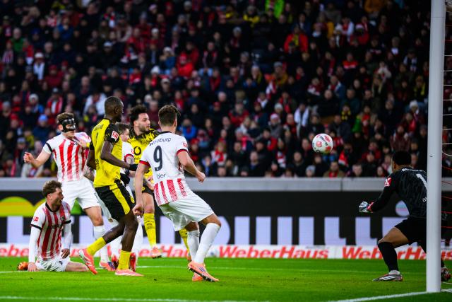 14 December 2025, Baden-Wuerttemberg, Freiburg im Breisgau: Borussia Dortmund's Ramy Bensebaini scores his side's first goal of the game during the German Bundesliga soccer match between SC Freiburg and Borussia Dortmund at Europa-Park Stadium. Photo: Tom Weller/dpa - WICHTIGER HINWEIS: Gemäß den Vorgaben der DFL Deutsche Fußball Liga bzw. des DFB Deutscher Fußball-Bund ist es untersagt, in dem Stadion und/oder vom Spiel angefertigte Fotoaufnahmen in Form von Sequenzbildern und/oder videoähnlichen Fotostrecken zu verwerten bzw. verwerten zu lassen.