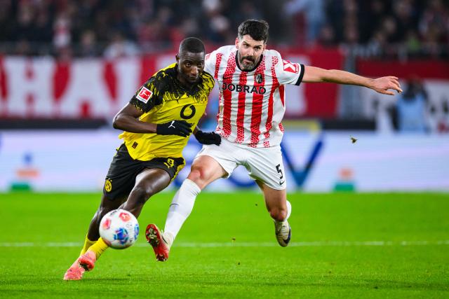 14 December 2025, Baden-Wuerttemberg, Freiburg im Breisgau: Borussia Dortmund's Serhou Guirassy (L) and Freiburg's Anthony Jung battle for the ball during the German Bundesliga soccer match between SC Freiburg and Borussia Dortmund at Europa-Park Stadium. Photo: Tom Weller/dpa - WICHTIGER HINWEIS: Gemäß den Vorgaben der DFL Deutsche Fußball Liga bzw. des DFB Deutscher Fußball-Bund ist es untersagt, in dem Stadion und/oder vom Spiel angefertigte Fotoaufnahmen in Form von Sequenzbildern und/oder videoähnlichen Fotostrecken zu verwerten bzw. verwerten zu lassen.