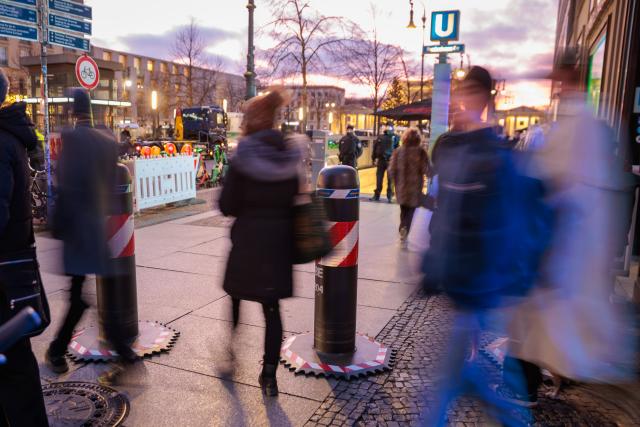 14 December 2025, Berlin: Passers-by walk past mobile barriers near the Brandenburg Gate. Inside the Chancellery, Ukrainian President Zelensky, his negotiators, and the US delegation hold initial talks on the next steps for a ceasefire in Ukraine. Photo: Carsten Koall/dpa