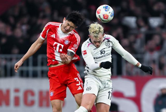 14 December 2025, Bavaria, Munich: Bayern Munich's Min-jae Kim (L) and Mainz's Benedict Hollerbach battle for the ball during the German Bundesliga soccer match between Bayern Munich and FSV Mainz 05 at the Allianz Arena. Photo: Sven Hoppe/dpa - WICHTIGER HINWEIS: Gemäß den Vorgaben der DFL Deutsche Fußball Liga bzw. des DFB Deutscher Fußball-Bund ist es untersagt, in dem Stadion und/oder vom Spiel angefertigte Fotoaufnahmen in Form von Sequenzbildern und/oder videoähnlichen Fotostrecken zu verwerten bzw. verwerten zu lassen.