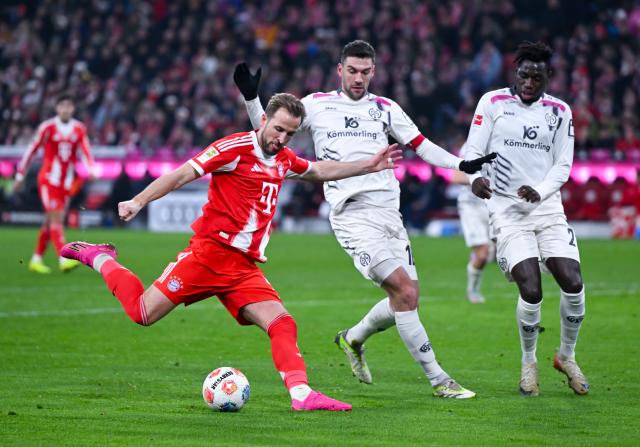 14 December 2025, Bavaria, Munich: Bayern Munich's Harry Kane (L) and Mainz's Stefan Bell (C) and Danny da Costa battle for the ball during the German Bundesliga soccer match between Bayern Munich and FSV Mainz 05 at the Allianz Arena. Photo: Sven Hoppe/dpa - WICHTIGER HINWEIS: Gemäß den Vorgaben der DFL Deutsche Fußball Liga bzw. des DFB Deutscher Fußball-Bund ist es untersagt, in dem Stadion und/oder vom Spiel angefertigte Fotoaufnahmen in Form von Sequenzbildern und/oder videoähnlichen Fotostrecken zu verwerten bzw. verwerten zu lassen.