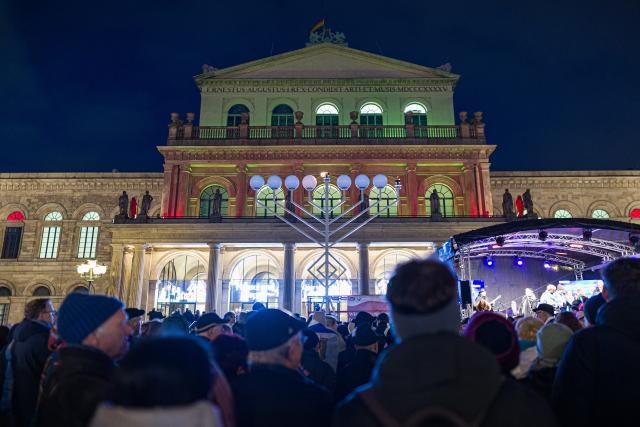 14 December 2025, Lower Saxony, Hanover: The Jewish community lights the menorah on Opera Square to mark the start of Hanukkah, the eight-day festival of lights commemorating the rededication of the Temple in Jerusalem in 165 BC. Photo: Moritz Frankenberg/dpa