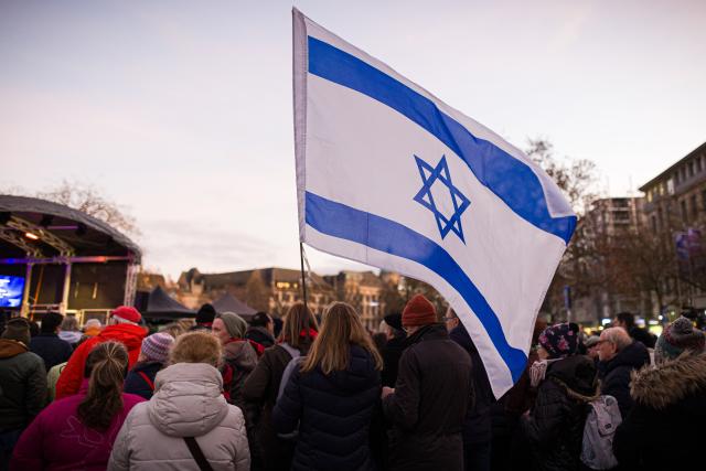 14 December 2025, Lower Saxony, Hanover: People watch the lighting of the Jewish community's menorah on Opera Square to mark the start of Hanukkah, the eight-day festival of lights commemorating the rededication of the Temple in Jerusalem in 165 BC. Photo: Moritz Frankenberg/dpa