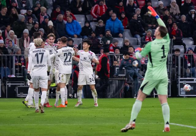 14 December 2025, Bavaria, Munich: Mainz players celebrate their side's first goal of the game during the German Bundesliga soccer match between Bayern Munich and FSV Mainz 05 at the Allianz Arena. Photo: Sven Hoppe/dpa - WICHTIGER HINWEIS: Gemäß den Vorgaben der DFL Deutsche Fußball Liga bzw. des DFB Deutscher Fußball-Bund ist es untersagt, in dem Stadion und/oder vom Spiel angefertigte Fotoaufnahmen in Form von Sequenzbildern und/oder videoähnlichen Fotostrecken zu verwerten bzw. verwerten zu lassen.