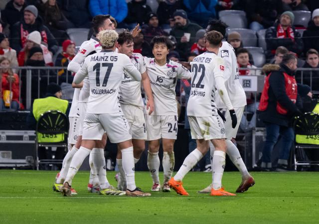 14 December 2025, Bavaria, Munich: Mainz players celebrate their side's first goal of the game during the German Bundesliga soccer match between Bayern Munich and FSV Mainz 05 at the Allianz Arena. Photo: Sven Hoppe/dpa - WICHTIGER HINWEIS: Gemäß den Vorgaben der DFL Deutsche Fußball Liga bzw. des DFB Deutscher Fußball-Bund ist es untersagt, in dem Stadion und/oder vom Spiel angefertigte Fotoaufnahmen in Form von Sequenzbildern und/oder videoähnlichen Fotostrecken zu verwerten bzw. verwerten zu lassen.