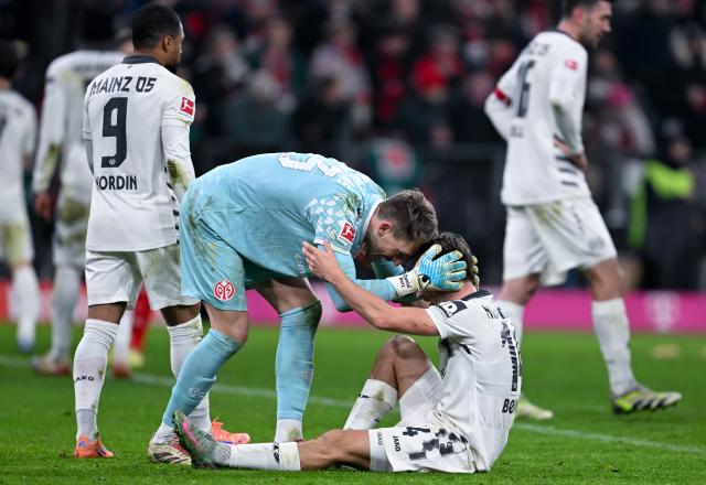 14 December 2025, Bavaria, Munich: Mainz's Daniel Batz (L) and William Boving stand on the pitch after the German Bundesliga soccer match between Bayern Munich and FSV Mainz 05 at the Allianz Arena. Photo: Sven Hoppe/dpa - WICHTIGER HINWEIS: Gemäß den Vorgaben der DFL Deutsche Fußball Liga bzw. des DFB Deutscher Fußball-Bund ist es untersagt, in dem Stadion und/oder vom Spiel angefertigte Fotoaufnahmen in Form von Sequenzbildern und/oder videoähnlichen Fotostrecken zu verwerten bzw. verwerten zu lassen.