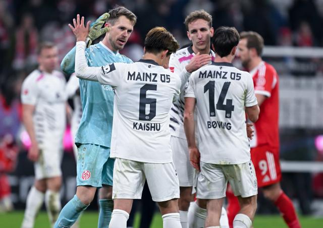 14 December 2025, Bavaria, Munich: (L-R) Mainz's Daniel Batz, Kaishu Sano and William Boving stand on the pitch after the German Bundesliga soccer match between Bayern Munich and FSV Mainz 05 at the Allianz Arena. Photo: Sven Hoppe/dpa - WICHTIGER HINWEIS: Gemäß den Vorgaben der DFL Deutsche Fußball Liga bzw. des DFB Deutscher Fußball-Bund ist es untersagt, in dem Stadion und/oder vom Spiel angefertigte Fotoaufnahmen in Form von Sequenzbildern und/oder videoähnlichen Fotostrecken zu verwerten bzw. verwerten zu lassen.