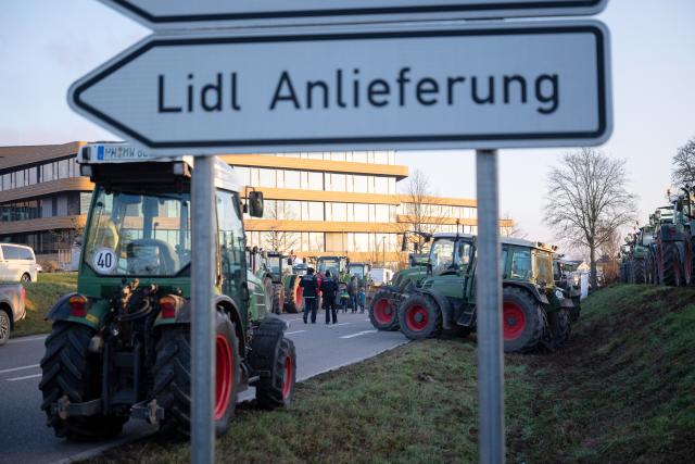 15 December 2025, Baden-Wuerttemberg, Bad Wimpfen: Farmers gather with their tractors outside Lidl's headquarters as part of a nationwide protest against persistently low milk and butter prices, calling for fairer returns for agricultural producers. Photo: Marijan Murat/dpa