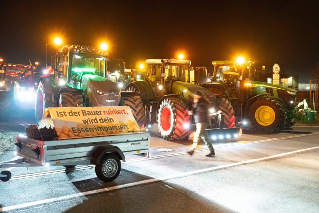15 December 2025, Saxony, Radeburg: Tractors block the entrance to a Lidl logistics centre as farmers stage a nationwide protest against persistently low milk and butter prices, highlighting growing frustration within the agricultural sector. Photo: Sebastian Kahnert/dpa