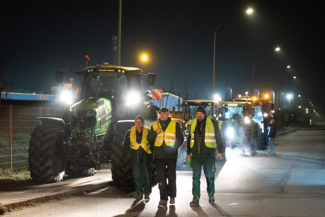 15 December 2025, Saxony, Radeburg: Tractors block the entrance to a Lidl logistics centre as farmers stage a nationwide protest against persistently low milk and butter prices, highlighting growing frustration within the agricultural sector. Photo: Sebastian Kahnert/dpa