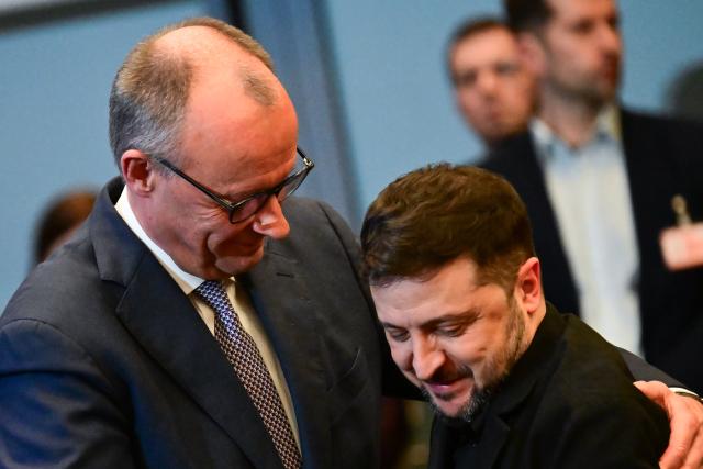 15 December 2025, Berlin: German Chancellor Friedrich Merz (L) and Ukrainian President Volodymyr Zelensky embrace during the German-Ukrainian Business Forum. At the same time, the German government is hosting delegations from the United States and Ukraine for talks on a proposed peace plan, including a possible ceasefire in Ukraine. Photo: Sebastian Christoph Gollnow/dpa
