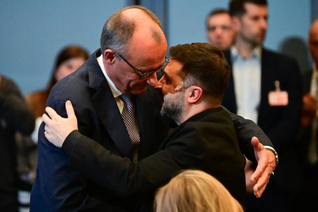 15 December 2025, Berlin: German Chancellor Friedrich Merz (L) and Ukrainian President Volodymyr Zelensky embrace during the German-Ukrainian Business Forum. At the same time, the German government is hosting delegations from the United States and Ukraine for talks on a proposed peace plan, including a possible ceasefire in Ukraine. Photo: Sebastian Christoph Gollnow/dpa