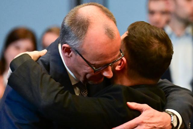 15 December 2025, Berlin: German Chancellor Friedrich Merz (L) and Ukrainian President Volodymyr Zelensky embrace during the German-Ukrainian Business Forum. At the same time, the German government is hosting delegations from the United States and Ukraine for talks on a proposed peace plan, including a possible ceasefire in Ukraine. Photo: Sebastian Christoph Gollnow/dpa