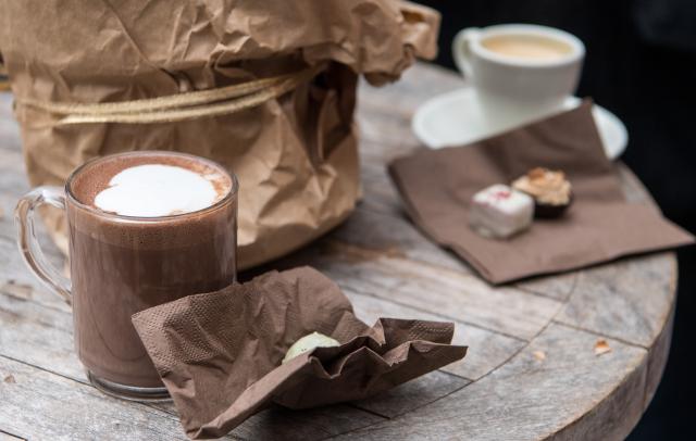 FILED - 05 December 2017, Baden-Württemberg, Tuebingen: A glass full of hot chocolate stands on a table at the chocolate market "chocolART"  in Tuebingen. A British study found that consuming foods and drinks rich in flavanols, such as tea, cocoa, apples, and berries, helps protect arteries from health problems that may result from sitting for long hours. Photo: picture alliance / Sebastian Gollnow/dpa