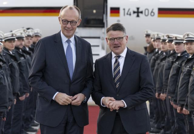 16 December 2025, Hesse, Frankfurt/Main: Boris Rhein (R), receives German Chancellor Friedrich Merz (CDU) at Frankfurt Airport. Photo: Boris Roessler/dpa