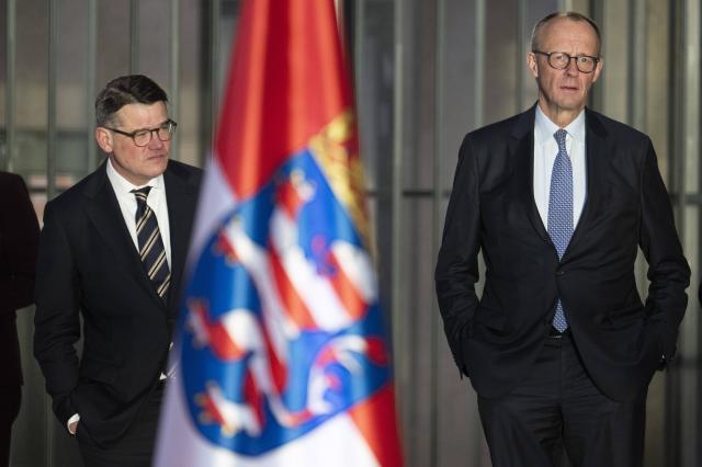 16 December 2025, Hesse, Frankfurt/Main: Minister-President of Hesse Boris Rhein (L), receives German Chancellor Friedrich Merz at Frankfurt Airport. Photo: Boris Roessler/dpa