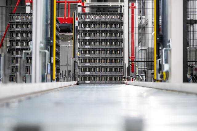 16 December 2025, Brandenburg, Grünheide: Boxes of battery cells stand in the Tesla Gigafactory Berlin-Brandenburg at the station from which the cells are brought to the production line for the battery modules and packs. Photo: Sebastian Gollnow/dpa