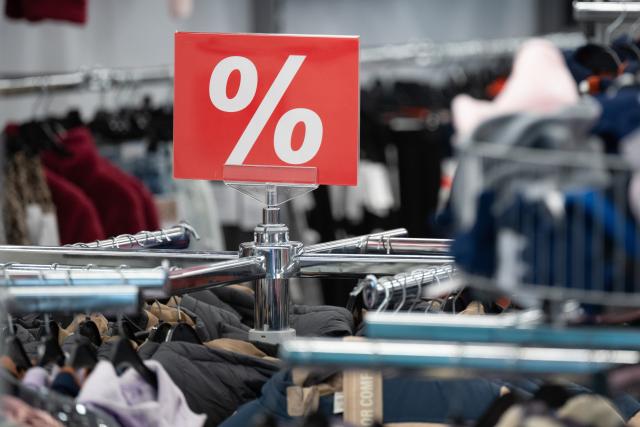 16 December 2025, Saxony, Dresden: A sign with the word "%" on a clothes rack. Photo: Sebastian Kahnert/dpa