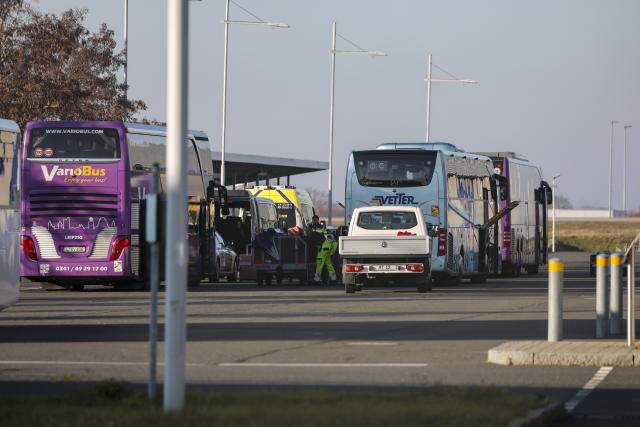 17 December 2025, Saxony, Schkeuditz: People load the luggage of migrants onto coaches at Leipzig/Halle Airport. The flight from Kenya took place as part of Germany's resettlement program. Photo: Jan Woitas/dpa