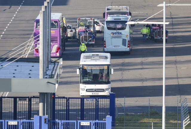 17 December 2025, Saxony, Schkeuditz: People load the luggage of migrants onto coaches at Leipzig/Halle Airport. The flight from Kenya took place as part of Germany's resettlement program. Photo: Jan Woitas/dpa