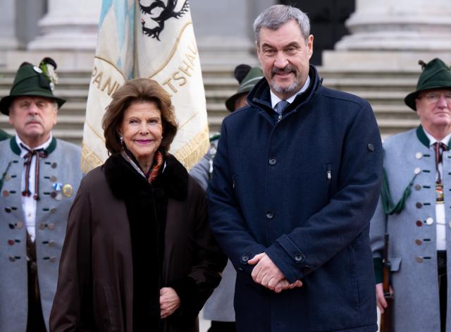 17 December 2025, Bavaria, Munich: Queen Silvia of Sweden is received by Markus Soeder, an honorary company of mountain riflemen and a delegation of traditional costume associations at Max-Joseph-Platz in front of the Munich Residence. Queen Silvia of Sweden receives the Bavarian State Medal for her special social commitment. Photo: Sven Hoppe/dpa