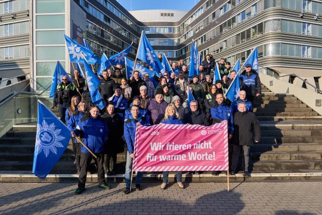 17 December 2025, Hamburg: Participants stand in front of police headquarters with a banner reading "We won't freeze for warm words!" during a warning strike and protest action by the dbb Beamtenbund and Tarifunion at police headquarters. The trade unions are demanding seven percent more pay for public sector employees, at least 300 euros. Photo: Georg Wendt/dpa