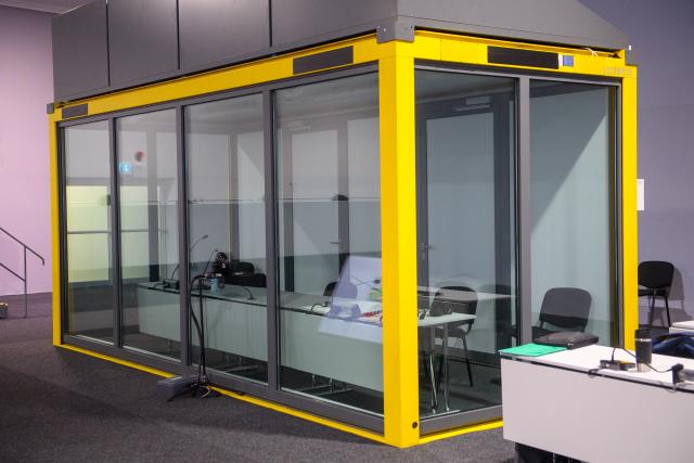 18 December 2025, Saxony-Anhalt, Magdeburg: View of the empty glass box in the courtroom of the temporary court building of the Magdeburg district court, where the driver killed at the Magdeburg Christmas market normally sits. The trial continued in the morning without the defendant. Photo: Klaus-Dietmar Gabbert/dpa
