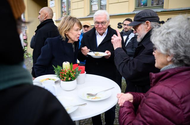 18 December 2025, Berlin: German President Frank-Walter Steinmeier (3rd from right to left) and his wife Elke Büdenbender visit the Straßenfeger association's day café in Prenzlauer Berg to celebrate the 30th anniversary of the street magazine of the same name and talk to people in need who have been given a free lunch. The Strassenfeger association has been helping people to find a way out of their emergency situation since 1994. Photo: Bernd von Jutrczenka/dpa