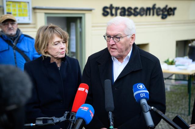 18 December 2025, Berlin: German President Frank-Walter Steinmeier (r-l) and his wife Elke Büdenbender speak to media representatives at the end of a visit to the Straßenfeger association's day café in Prenzlauer Berg to mark the 30th anniversary of the street magazine of the same name. The Strassenfeger association has been helping people to find a way out of their emergency situation since 1994. Photo: Bernd von Jutrczenka/dpa