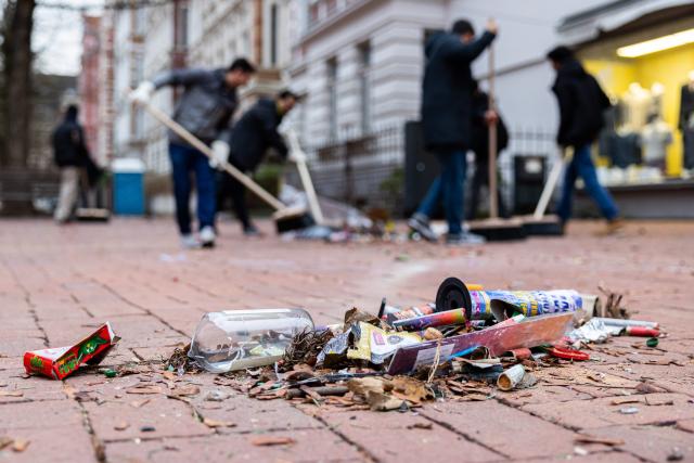 FILED - 01 January 2023, Bremen, Hanover: Members of the Muslim association "Majlis Khuddam-ul-Ahmadiyya Deutschland" support street cleaning staff on New Year's morning by removing the remains of New Year's Eve. Members of Germany's Muslim community will take part in a nationwide clean-up campaign following New Year's celebrations, Berlin's Imam Sharjeel Khalid told dpa on Thursday. Photo: Michael Matthey/dpa