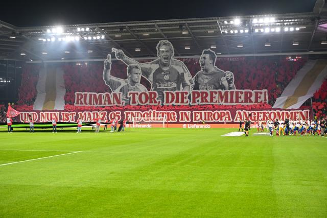 18 December 2025, Rhineland-Palatinate, Mainz: A banner reading "Ruman, goal, the premiere! And now Mainz 05 has finally arrived in Europe!" is displayed ahead of the UEFA Europa Conference League soccer match between FSV Mainz 05 and Samsunspor at the Mewa Arena. Photo: Torsten Silz/dpa