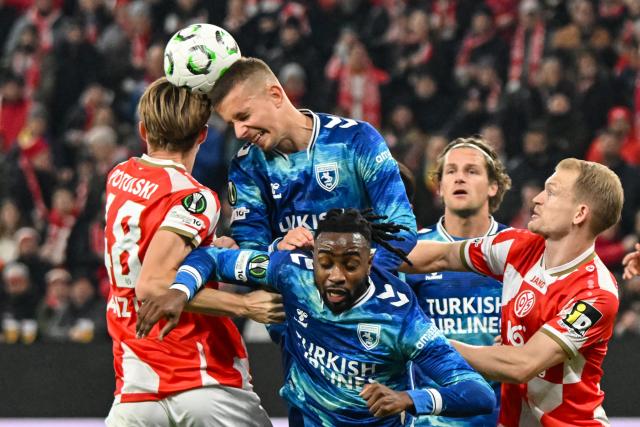 18 December 2025, Rhineland-Palatinate, Mainz: Mainz's Kacper Potulski (L) and Samsunspor's Rick van Drongelen battle for the ball during the UEFA Europa Conference League soccer match between FSV Mainz 05 and Samsunspor at the Mewa Arena. Photo: Torsten Silz/dpa