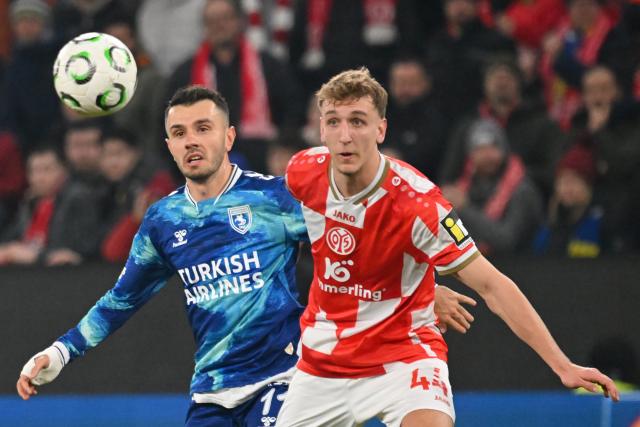 18 December 2025, Rhineland-Palatinate, Mainz: Samsunspor's Emre Kilinc (L) and Mainz's Nelson Weiper (R) battle for the ball during the UEFA Europa Conference League soccer match between FSV Mainz 05 and Samsunspor at the Mewa Arena. Photo: Torsten Silz/dpa