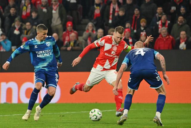 18 December 2025, Rhineland-Palatinate, Mainz: Mainz's Silvan Widmer (C) scores his side's first goal of the game during the UEFA Europa Conference League soccer match between FSV Mainz 05 and Samsunspor at the Mewa Arena. Photo: Torsten Silz/dpa