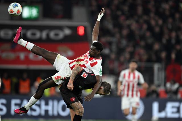 FILED - 13 December 2025, North Rhine-Westphalia, Leverkusen: Bayer Leverkusen's Robert Andrich (Down) and Cologne's Ragnar Ache battle for the ball during the German Bundesliga soccer match between Bayer Leverkusen and 1. FC Cologne at BayArena. Photo: Federico Gambarini/dpa - WICHTIGER HINWEIS: Gemäß den Vorgaben der DFL Deutsche Fußball Liga bzw. des DFB Deutscher Fußball-Bund ist es untersagt, in dem Stadion und/oder vom Spiel angefertigte Fotoaufnahmen in Form von Sequenzbildern und/oder videoähnlichen Fotostrecken zu verwerten bzw. verwerten zu lassen.