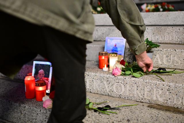 19 December 2025, Berlin: A man lays flowers at the "Der Riss" memorial before the official commemoration of the 2016 attack on the Breitscheidplatz Christmas market. Photo: Sebastian Christoph Gollnow/dpa