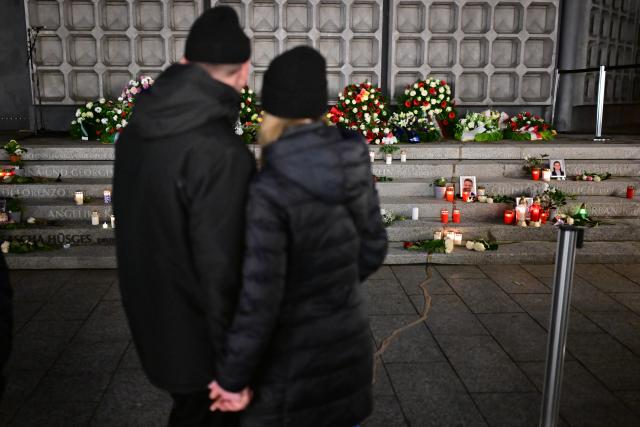 19 December 2025, Berlin: People look at the "Der Riss" memorial before the official commemoration of the 2016 attack on the Breitscheidplatz Christmas market. Photo: Sebastian Christoph Gollnow/dpa