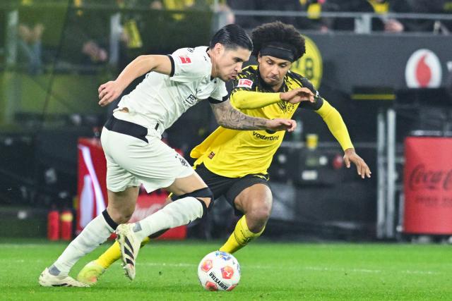 19 December 2025, North Rhine-Westphalia, Dortmund: Gladbach's Kevin Diks and Dortmund's Karim Adeyemi (R) in action during the German Bundesliga soccer match between Borussia Dortmund and Borussia Moenchengladbach at the Signal Iduna Park. Photo: Bernd Thissen/dpa