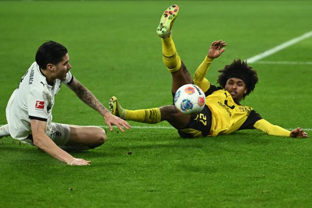19 December 2025, North Rhine-Westphalia, Dortmund: Gladbach's Kevin Diks and Dortmund's Karim Adeyemi (R) collide during the German Bundesliga soccer match between Borussia Dortmund and Borussia Moenchengladbach at the Signal Iduna Park. Photo: Bernd Thissen/dpa