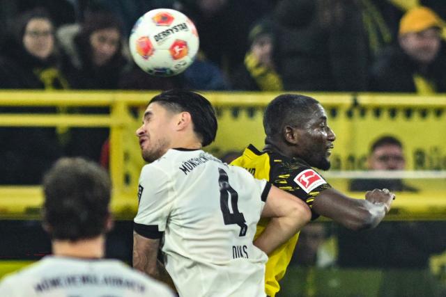 19 December 2025, North Rhine-Westphalia, Dortmund: Gladbach's Kevin Diks and Dortmund's Serhou Guirassy (R) battle for a header during the German Bundesliga soccer match between Borussia Dortmund and Borussia Moenchengladbach at the Signal Iduna Park. Photo: Bernd Thissen/dpa